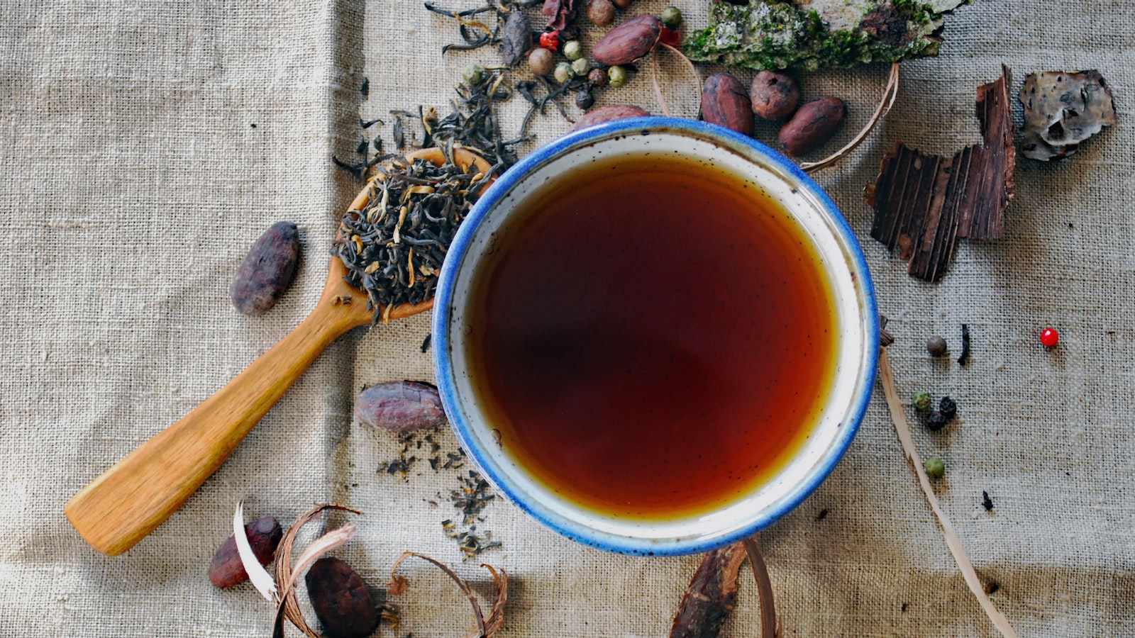 Hot water being poured over tea leaves in a clear glass cup