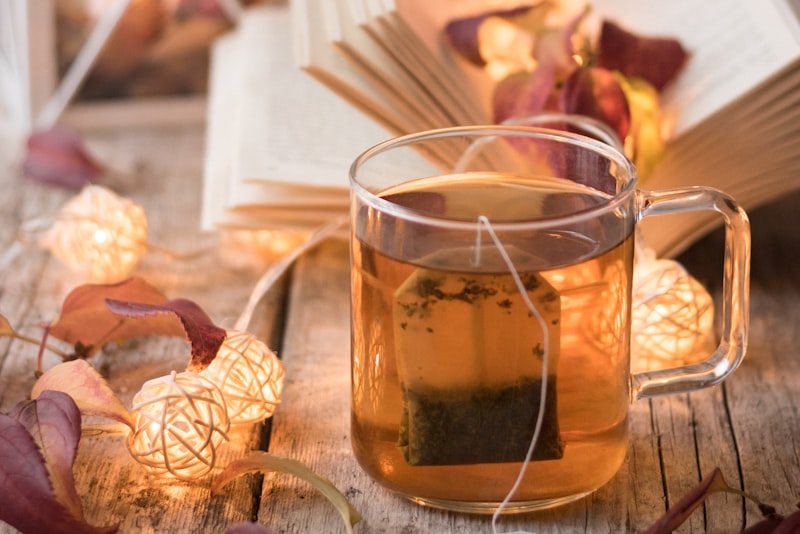 A cup of dark black tea on a wooden table